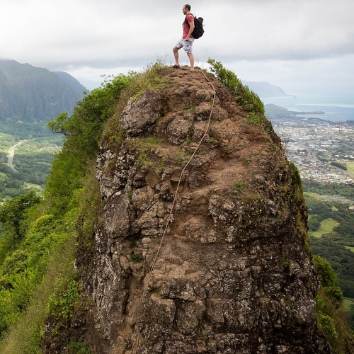 Einen Bergsteiger auf dem Berg, der ins Tal schaut.
